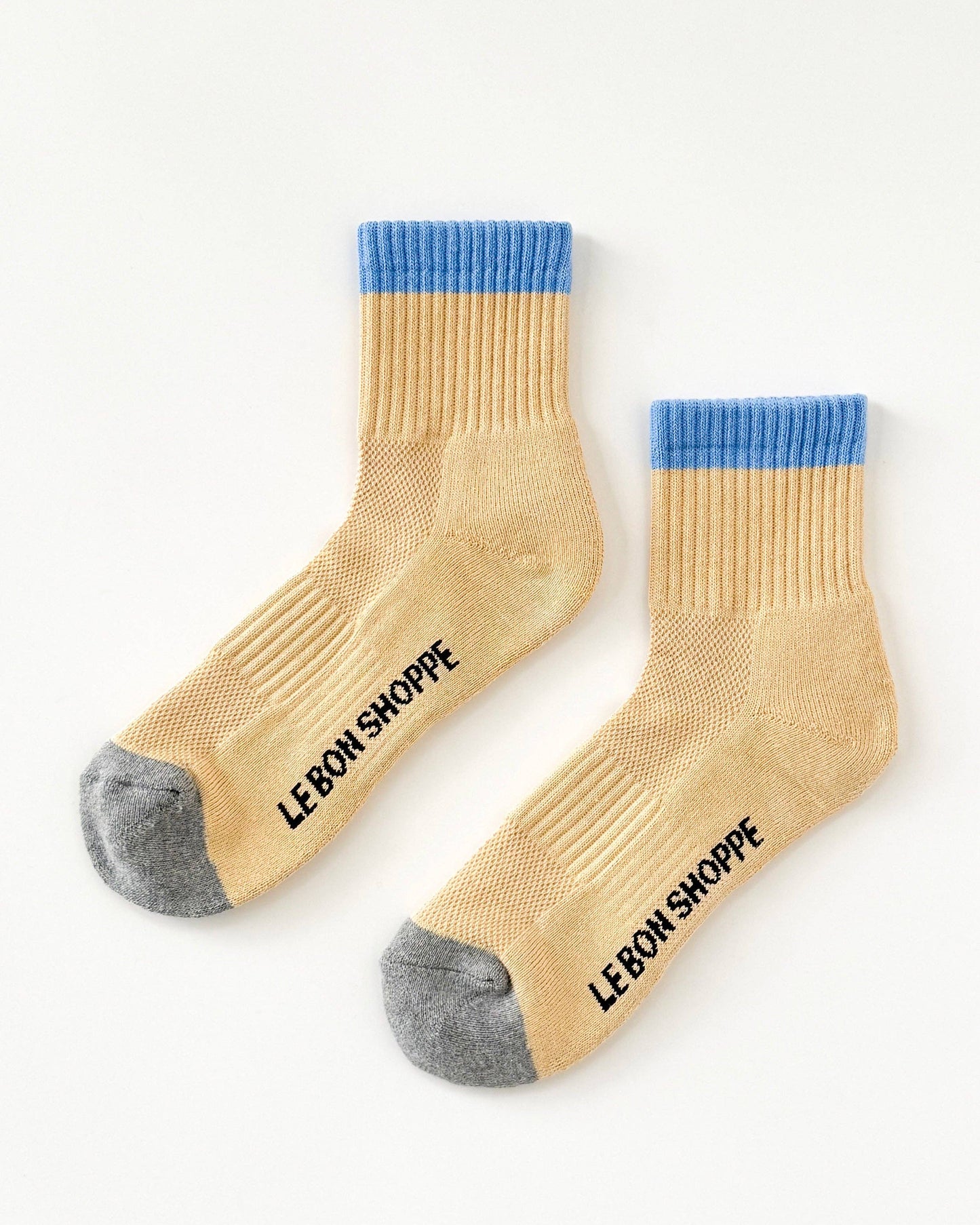 Beige socks with blue tops and gray toes on a white background, featuring 'Le Bon Shoppe' branding.