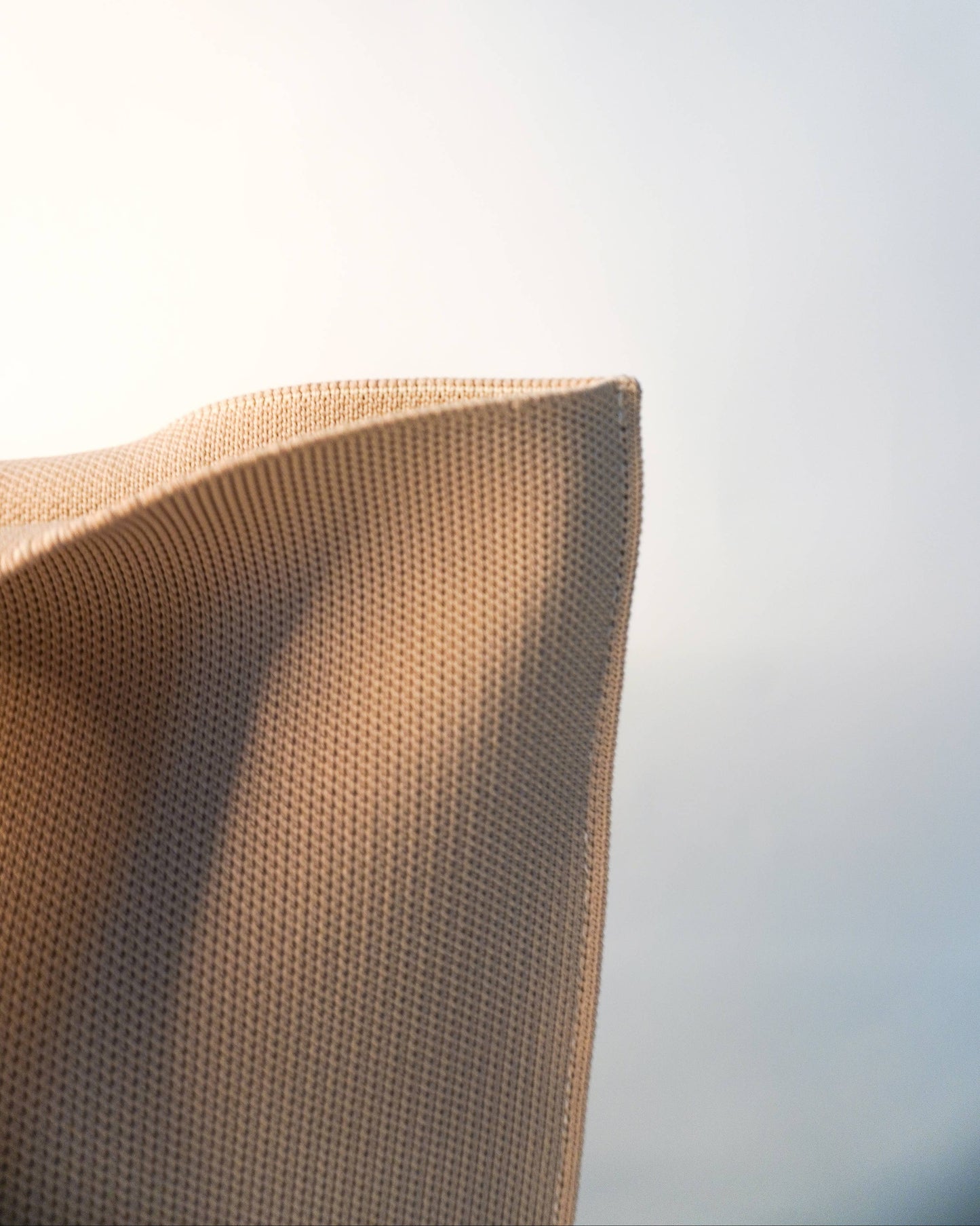 Close-up of a textured brown pillow against a blurred light background