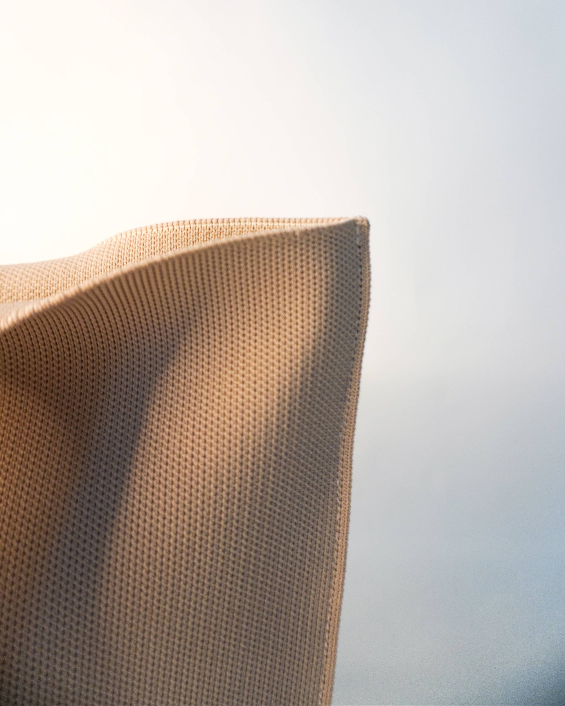 Close-up of a textured brown pillow against a blurred light background
