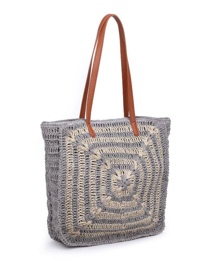 Woven tote bag with brown handle on a white background