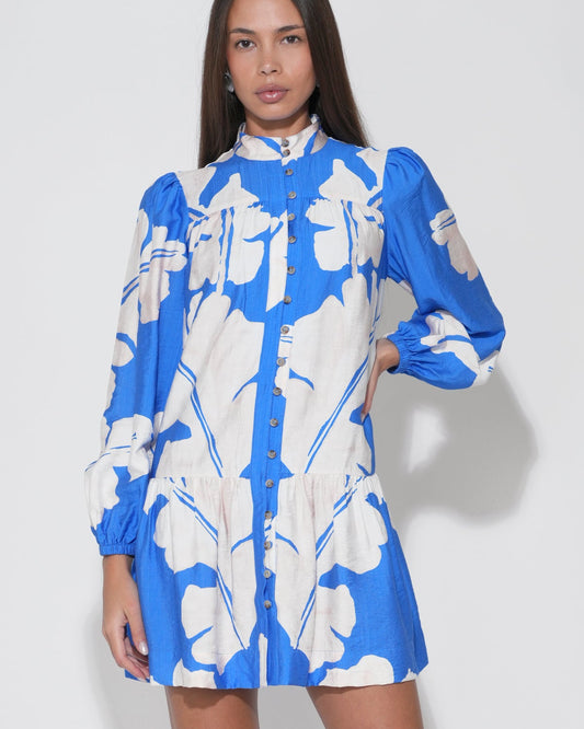 Woman wearing a blue and white floral dress against a white background