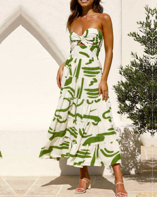  Model is wearing Rosa Clothing Twist Front Strapless Maxi Dress in green with white sandals on a white background