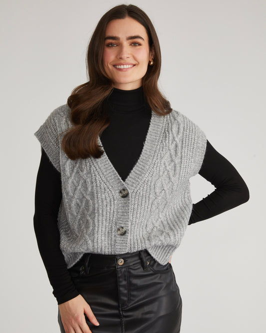 Model wearing 525 America Paige Button Front Cable Vest in grey color wearing black skirt and black shirt on a white background