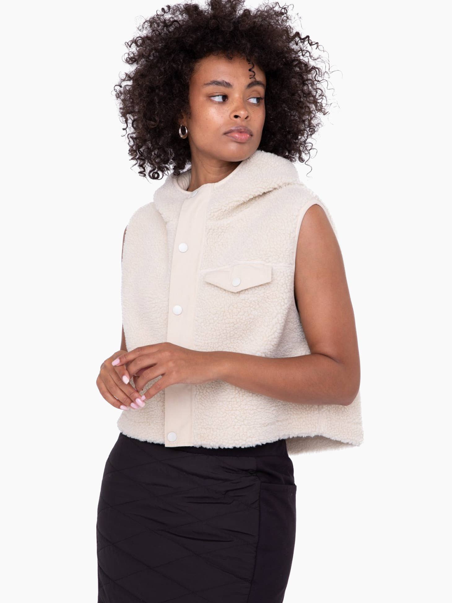Model wearing Mono B Sherpa Cropped Hoodie vest wearing black skirt on a white background