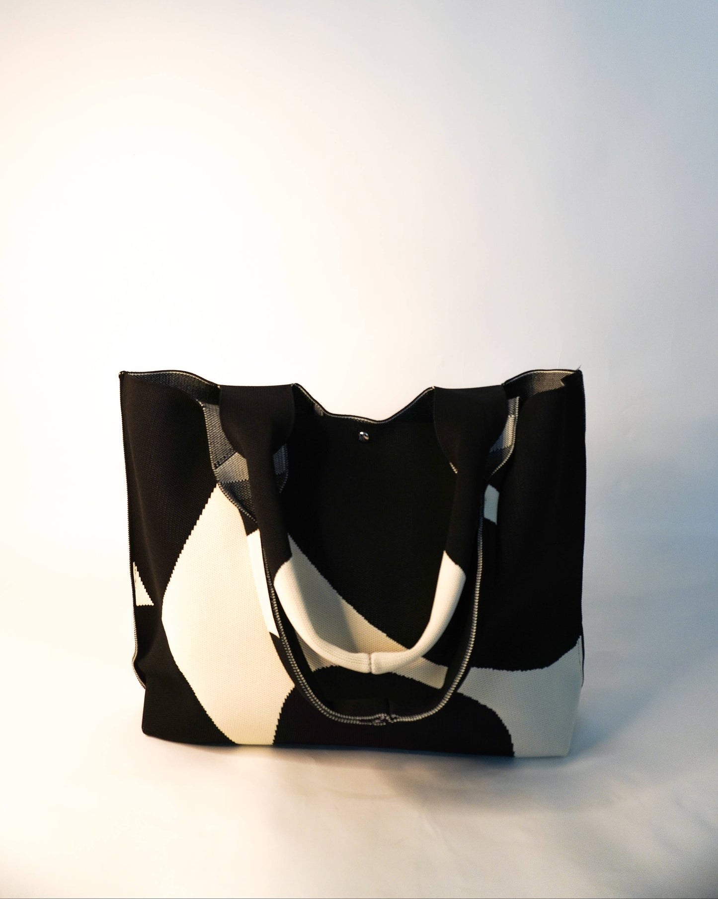 Black and white tote bag on a light gray background