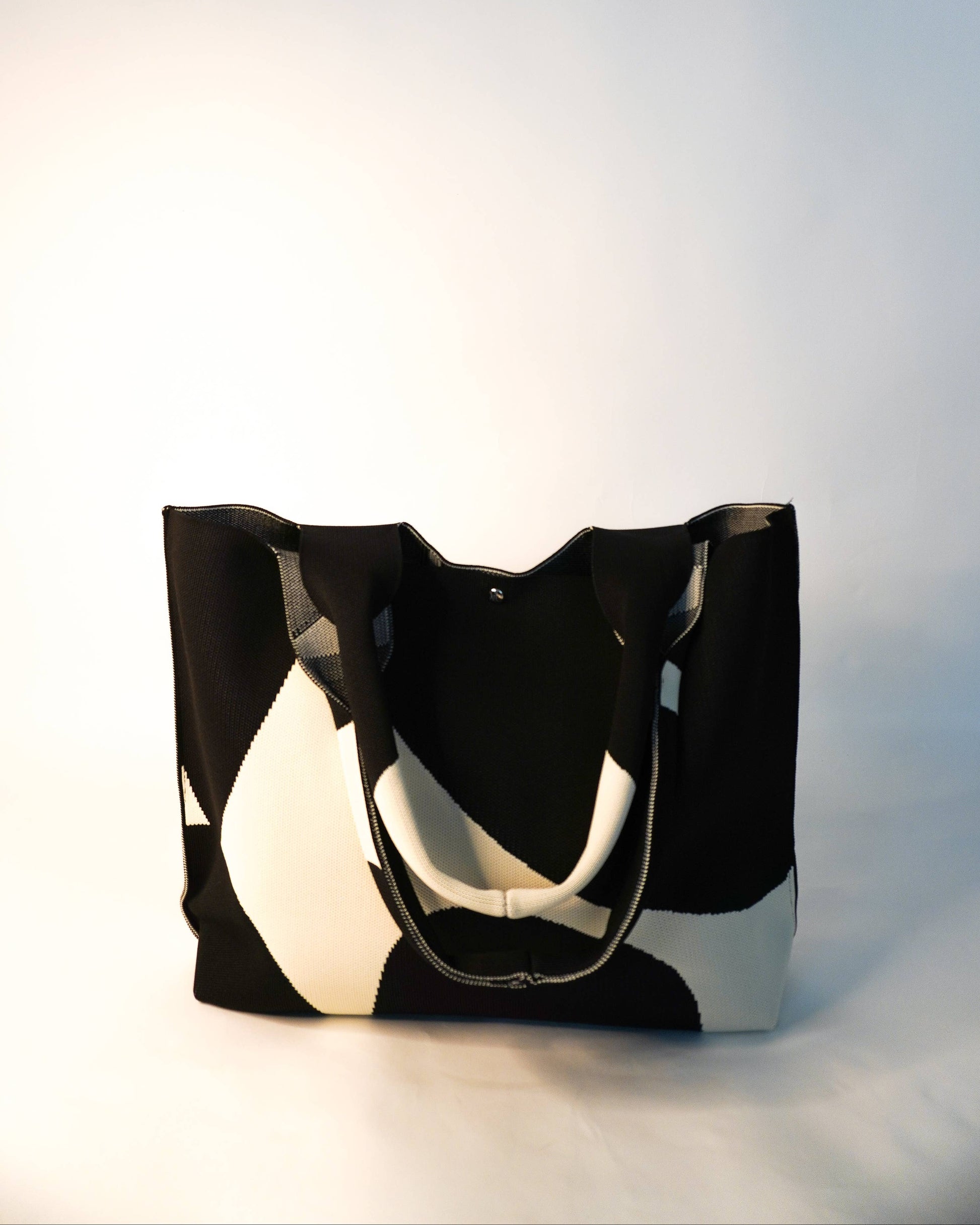 Black and white tote bag on a light gray background