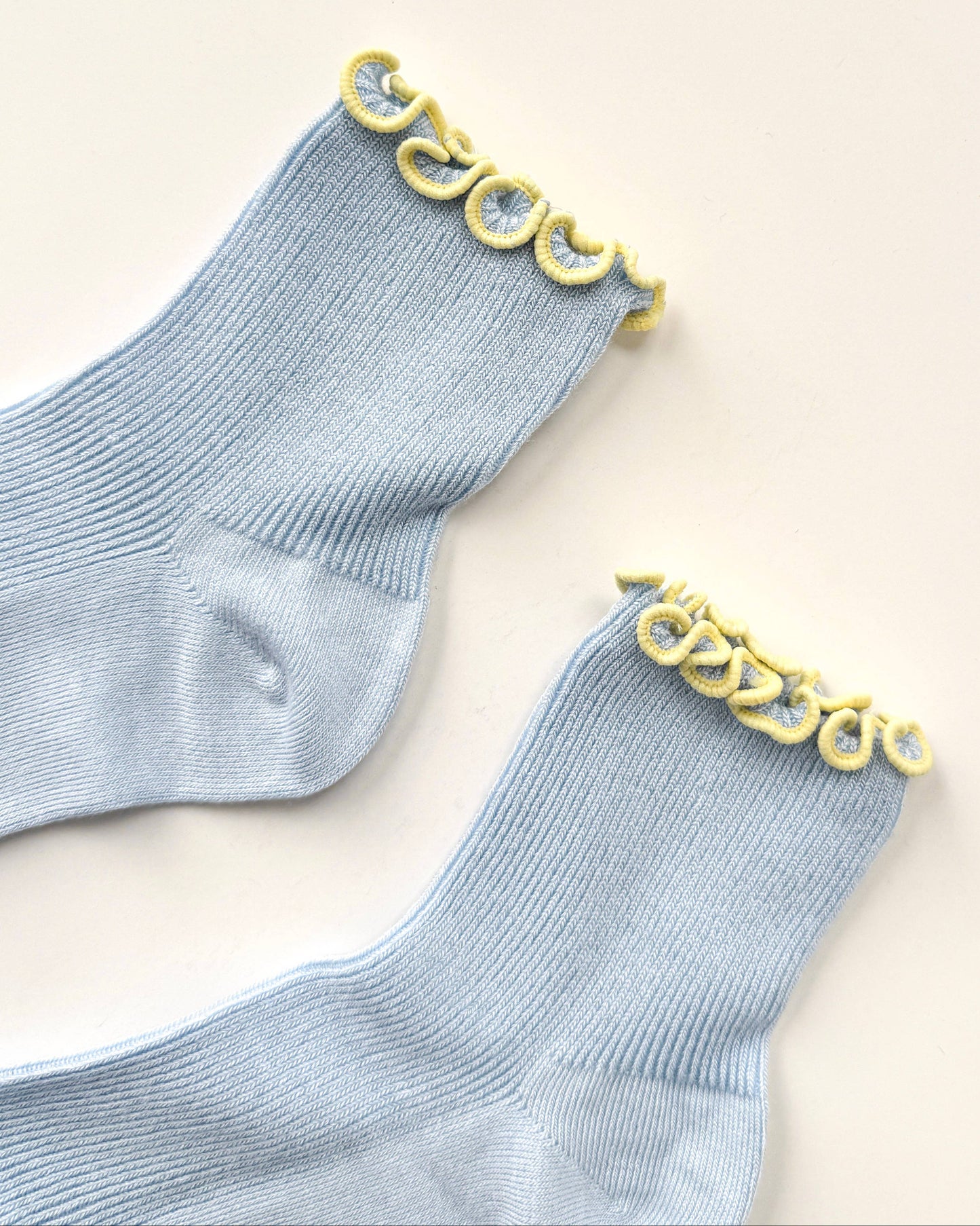 Gray socks with yellow decorative trim on a beige background