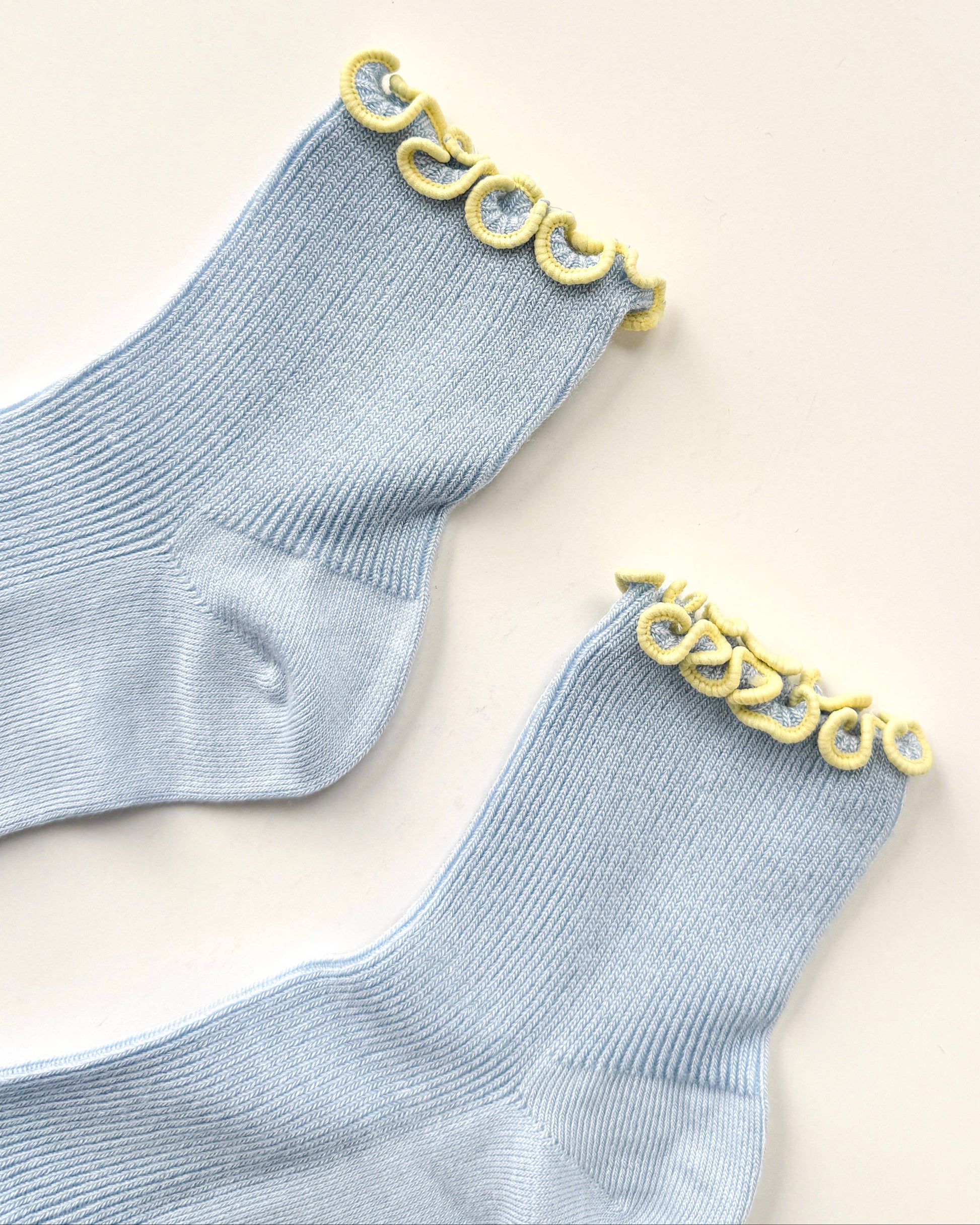 Gray socks with yellow decorative trim on a beige background