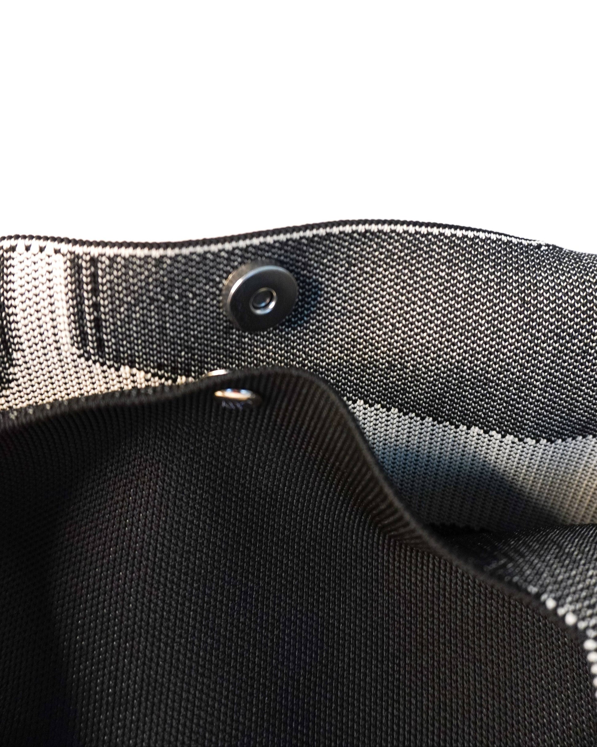 Close-up of a black belt with a button on a white background