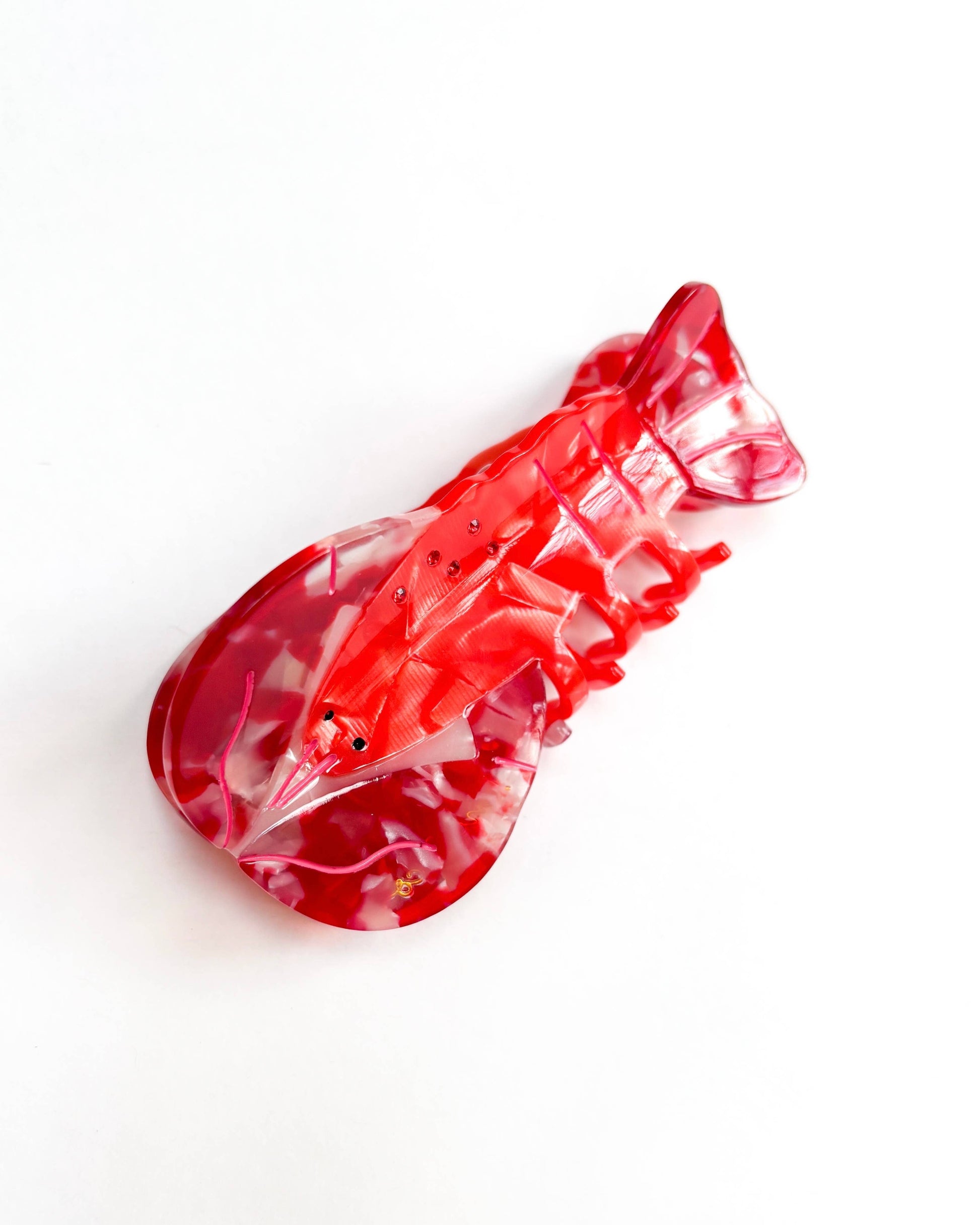 Red and white shaped Lobster hair clip on a white background