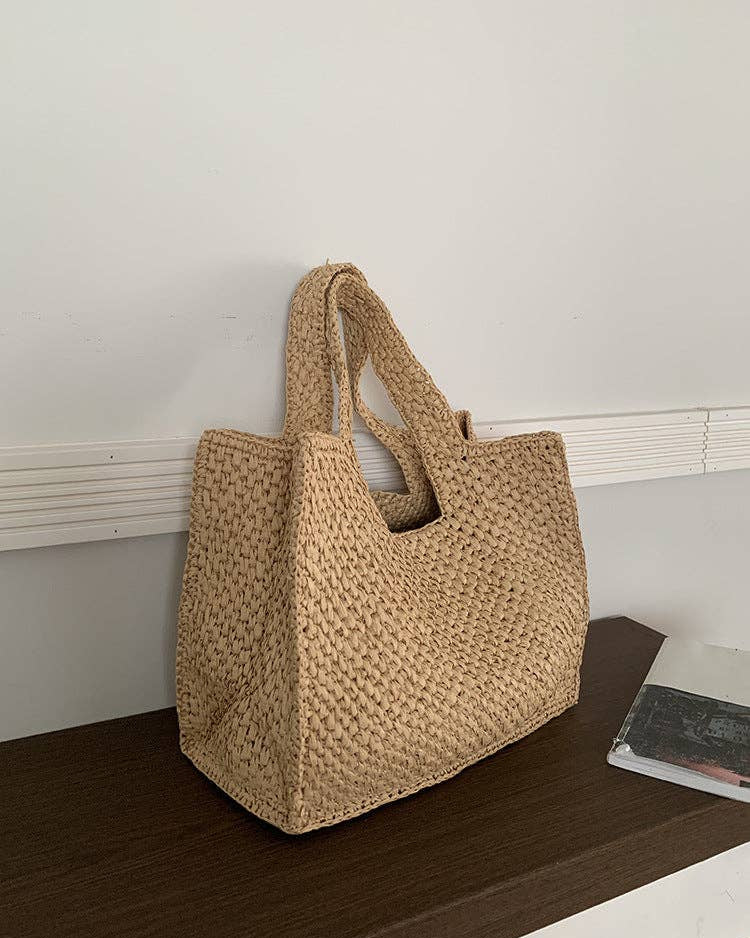 Woven beige handbag on a wooden surface with a neutral background