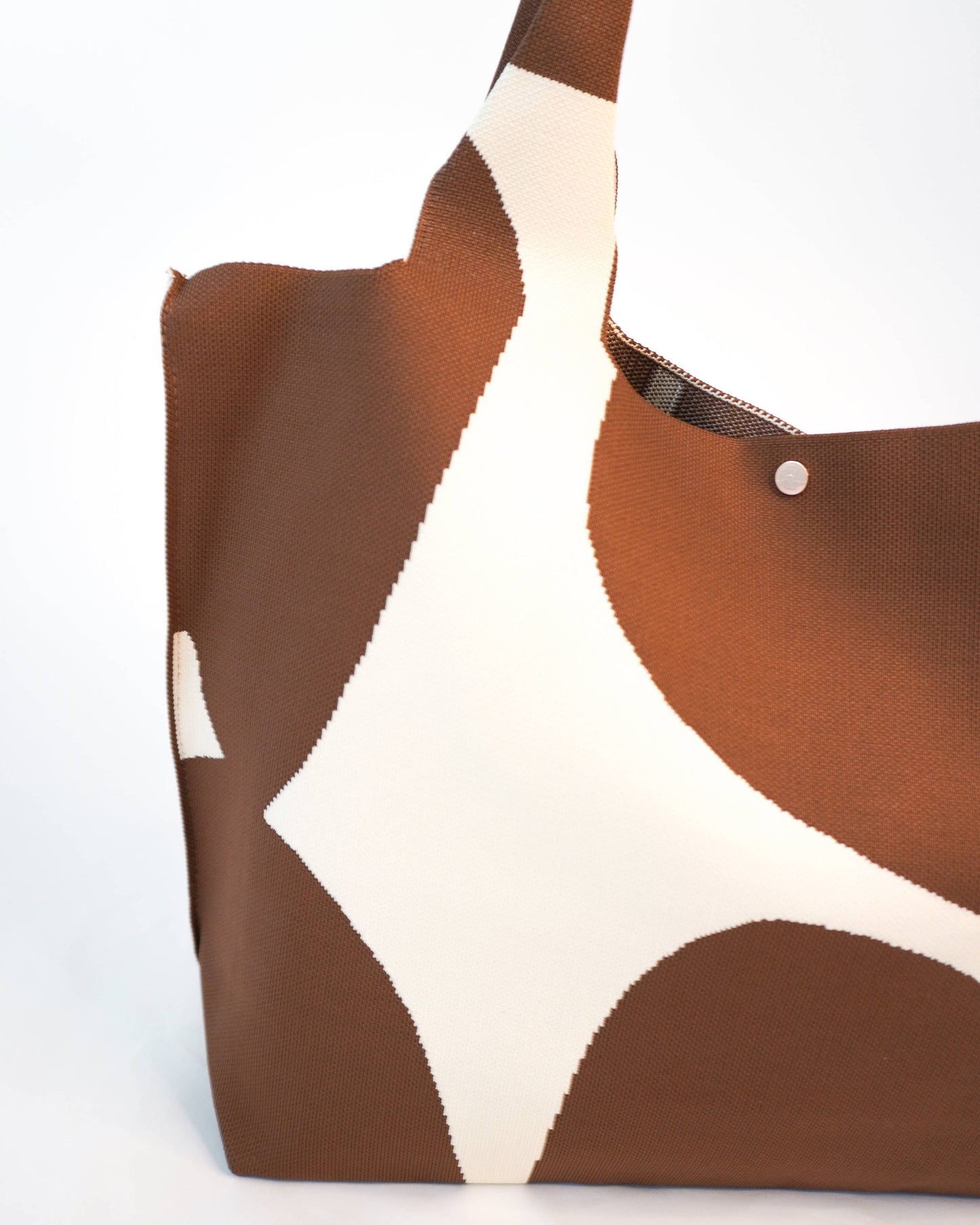 Brown and white patterned tote bag on a white background