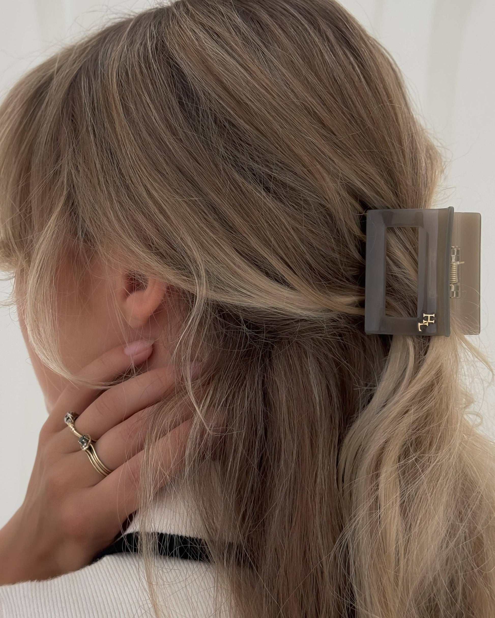 Woman with blonde hair wearing the HoneyLux Dolce Midi Acetate Claw clip in the color Capri Stone against a white background