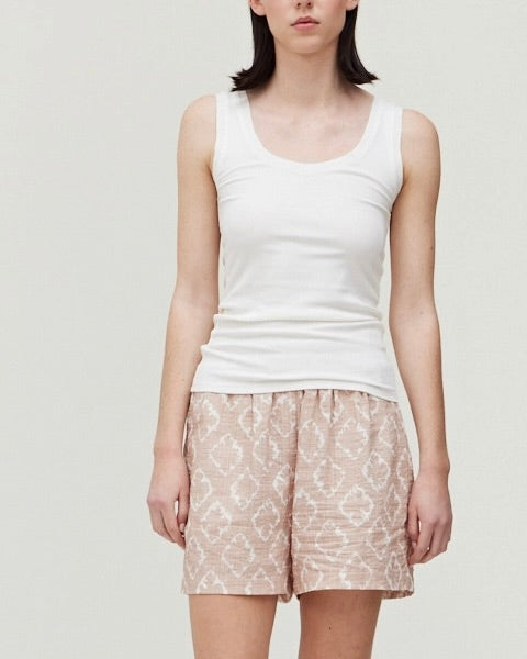 Model wearing Grade & Gather Ikat Pink sand print shorts wearing white tank on a white background