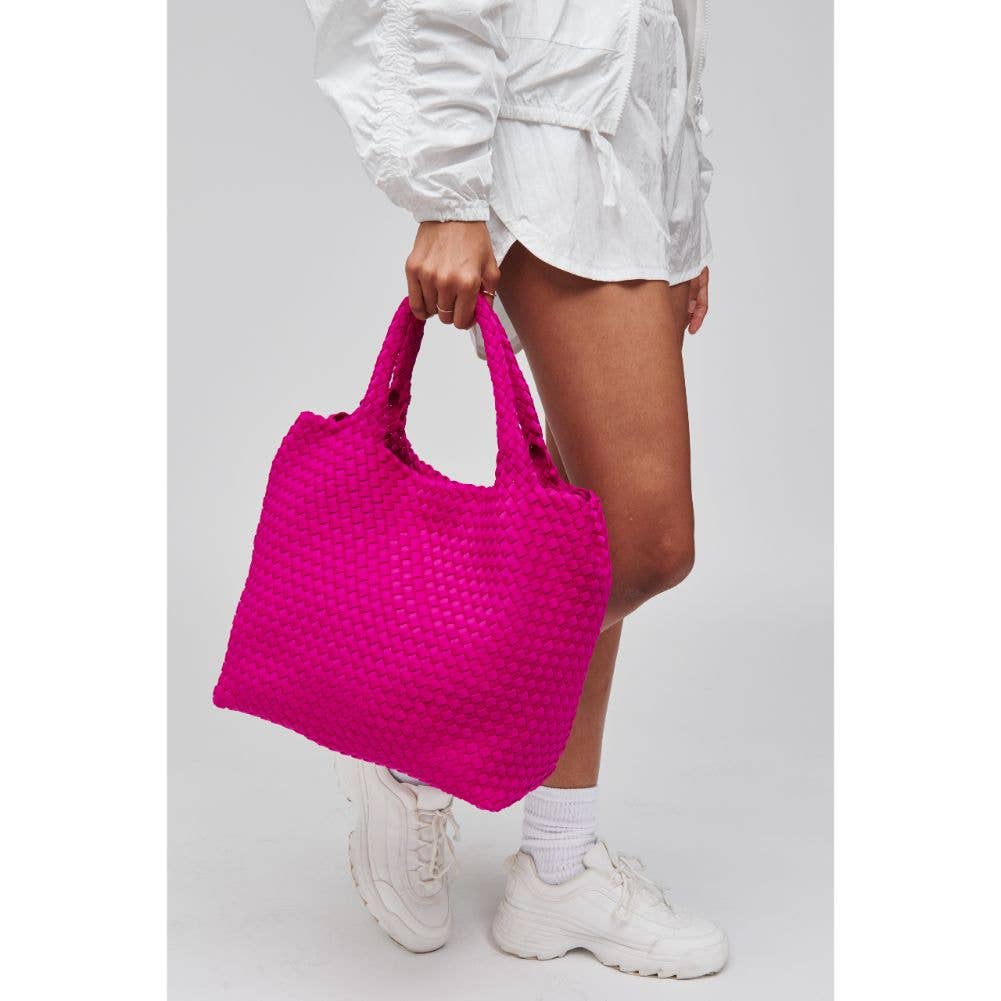 Model holding Sol & Sky's The Limit Medium Woven Neoprene Tote page in Fuschia wearing white and white shoes on a gray background and white boarder