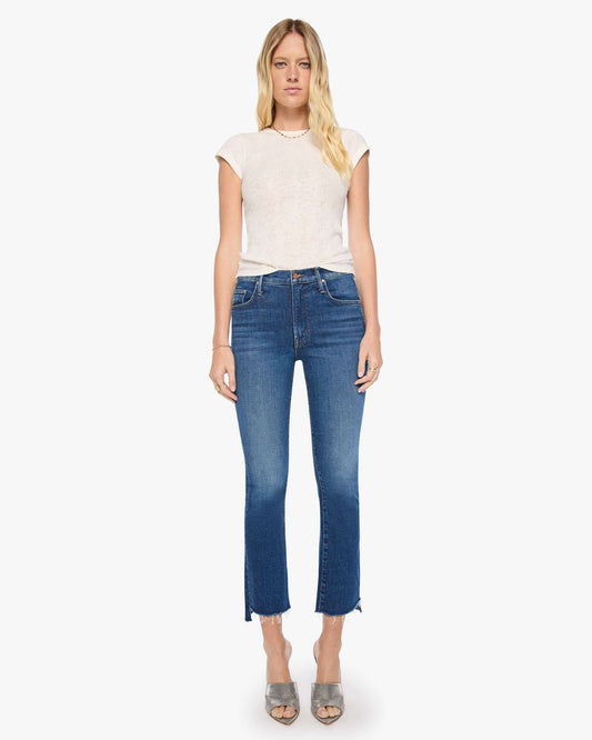 Woman wearing a white top and blue jeans on a white background