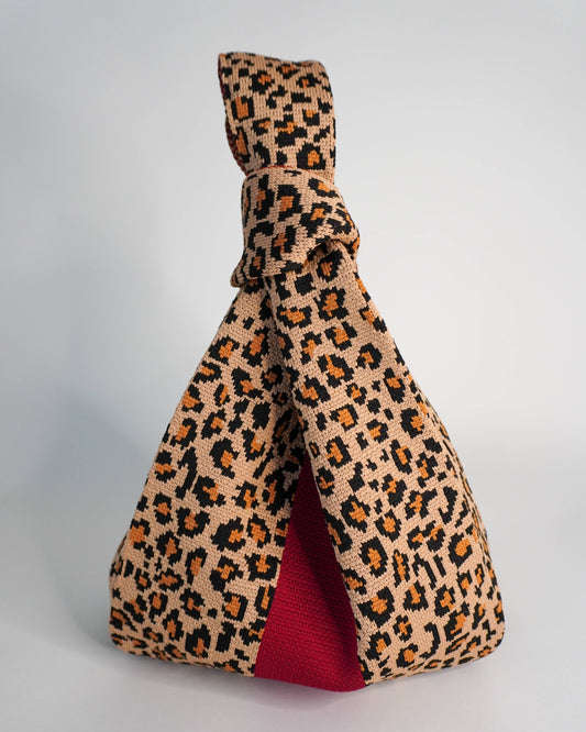 Leopard print bag with a red stripe on a gray background