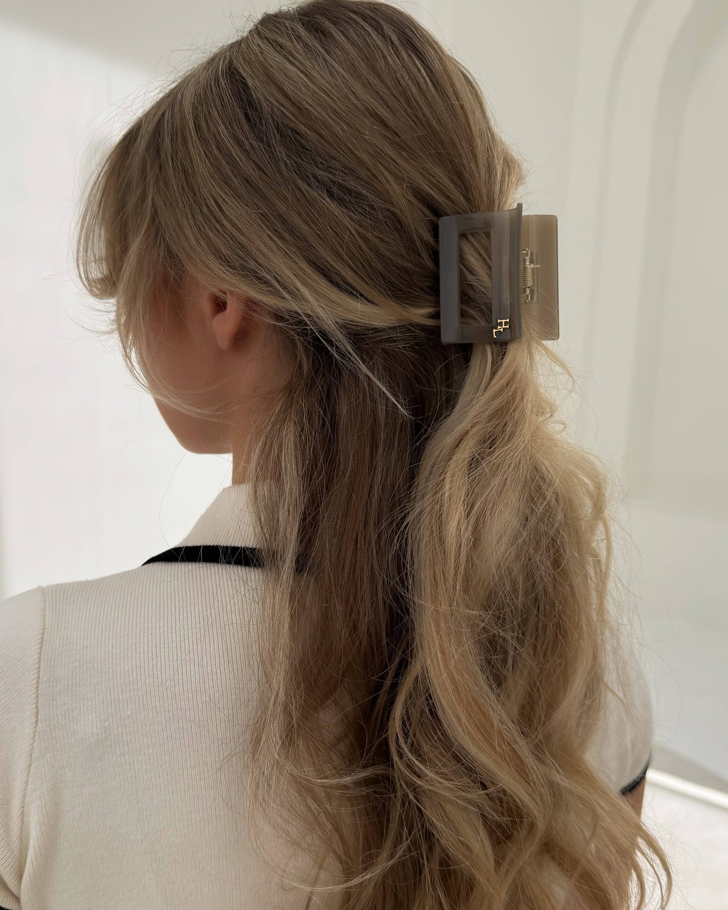 Woman wearing the HoneyLux Dolce Midi Acetate Claw clip in the color Capri Stone against a neutral background.