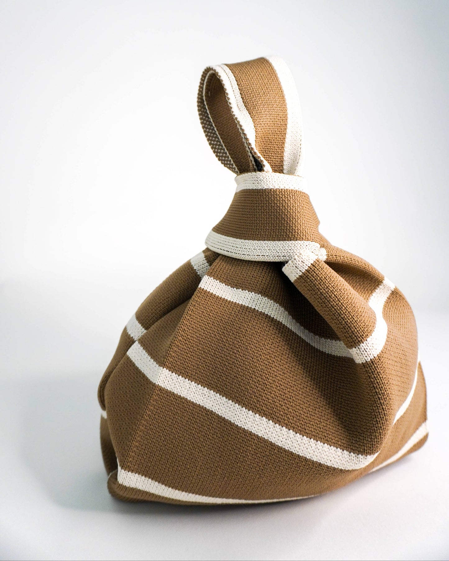 Brown drawstring bag with white accents on a light gray background