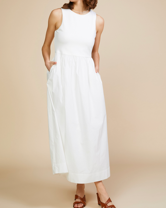 Model wearing Skies are blue Alice High Neck Midi Dress in white on a beige background