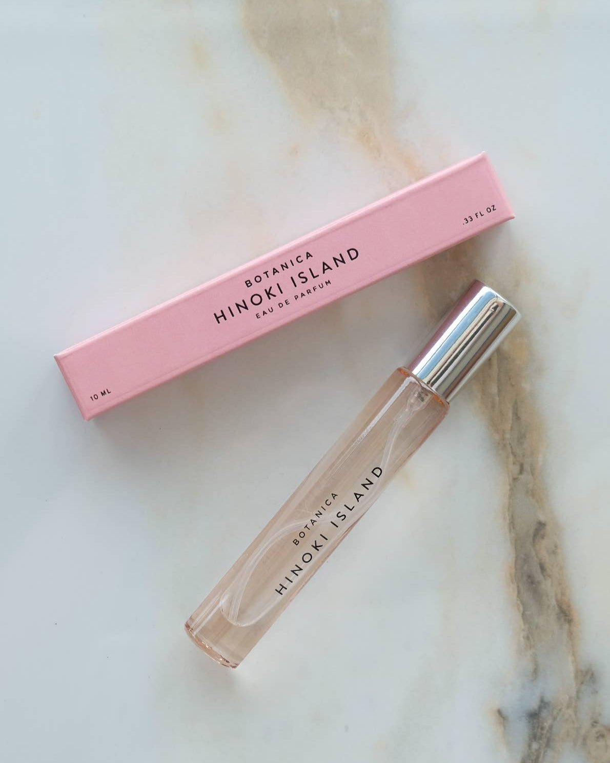 Botanica Hinoki Island perfume bottle and packaging on a marble surface