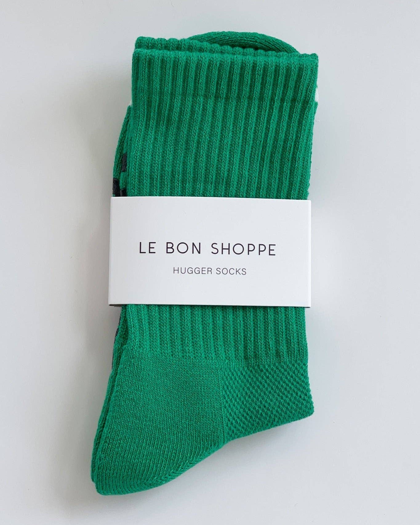Green socks with a white label on a light gray background