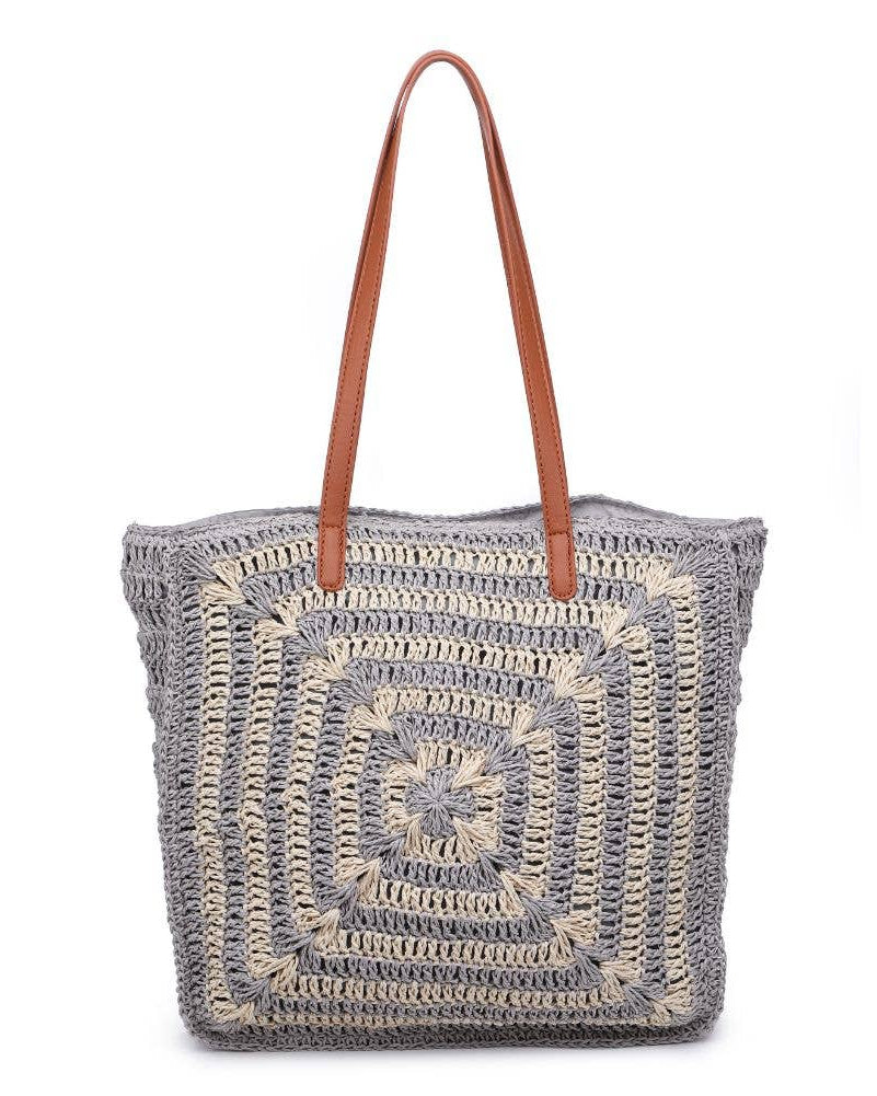 Crocheted tote bag with brown leather handle on a white background