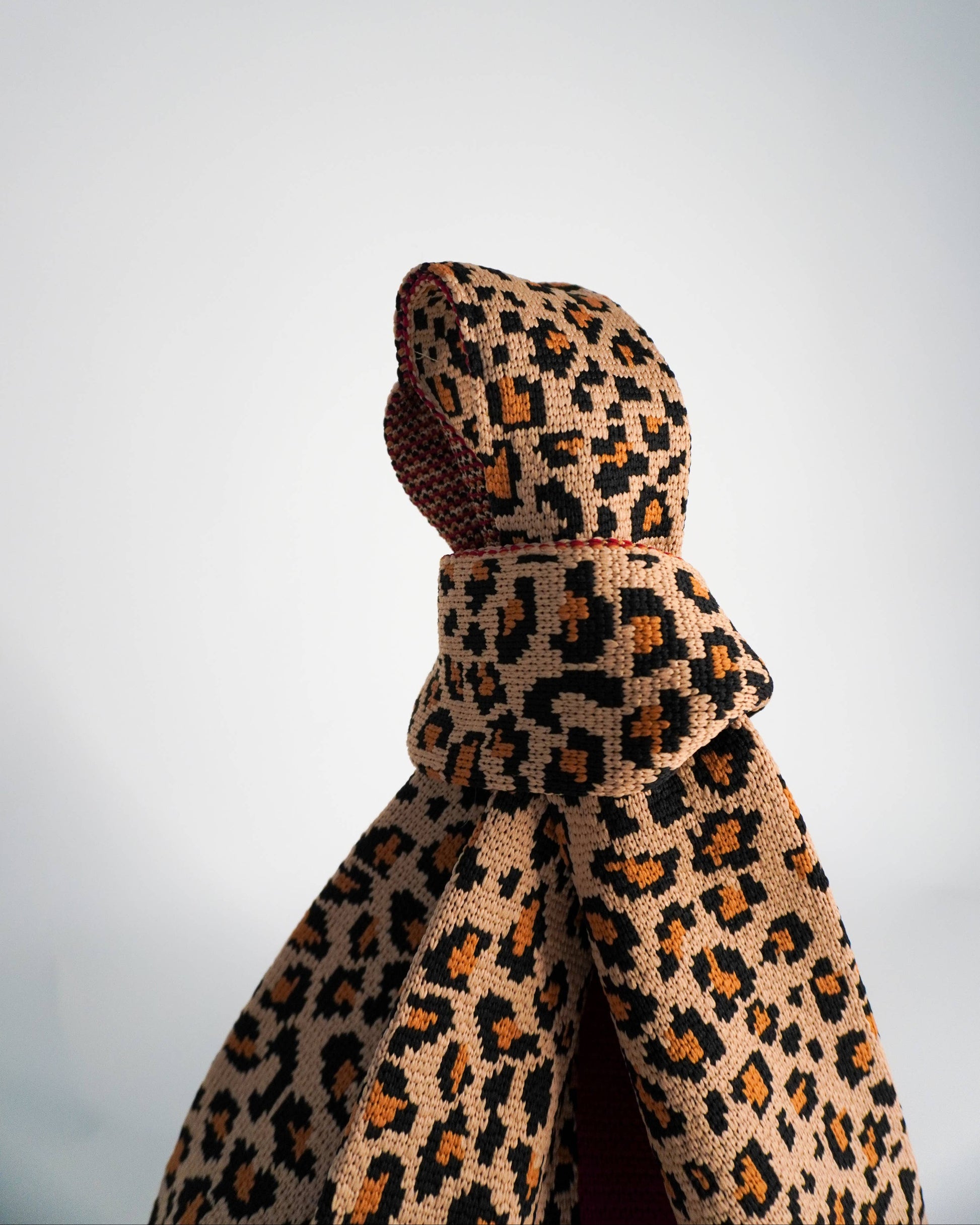 Leopard print bag handles on a plain background