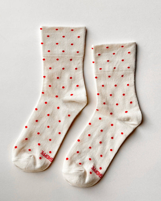 White socks with red polka dots on a light gray background