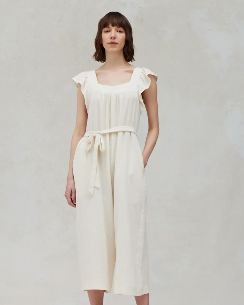 Model Wearing Grade & Gather Solid Gauze Jumpsuit in Soy Color On A White Background