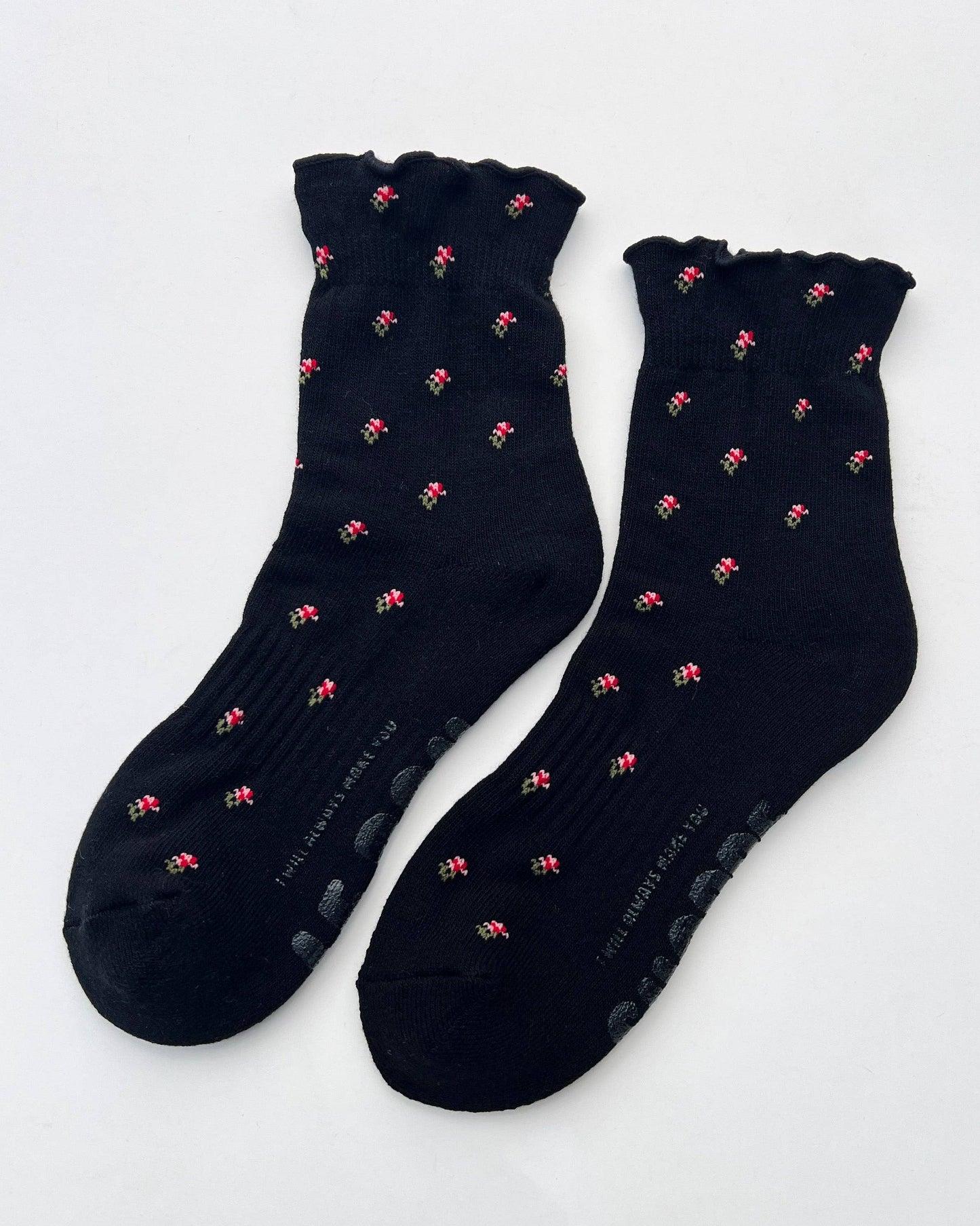Pair of black socks with pink patterns on a white background