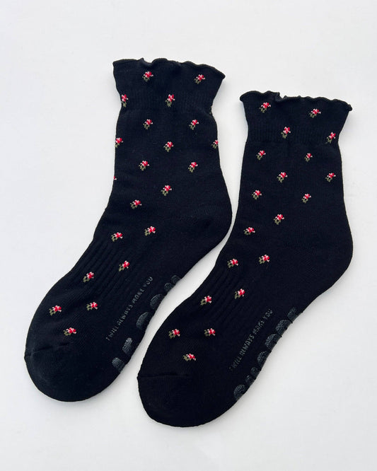Pair of black socks with pink patterns on a white background