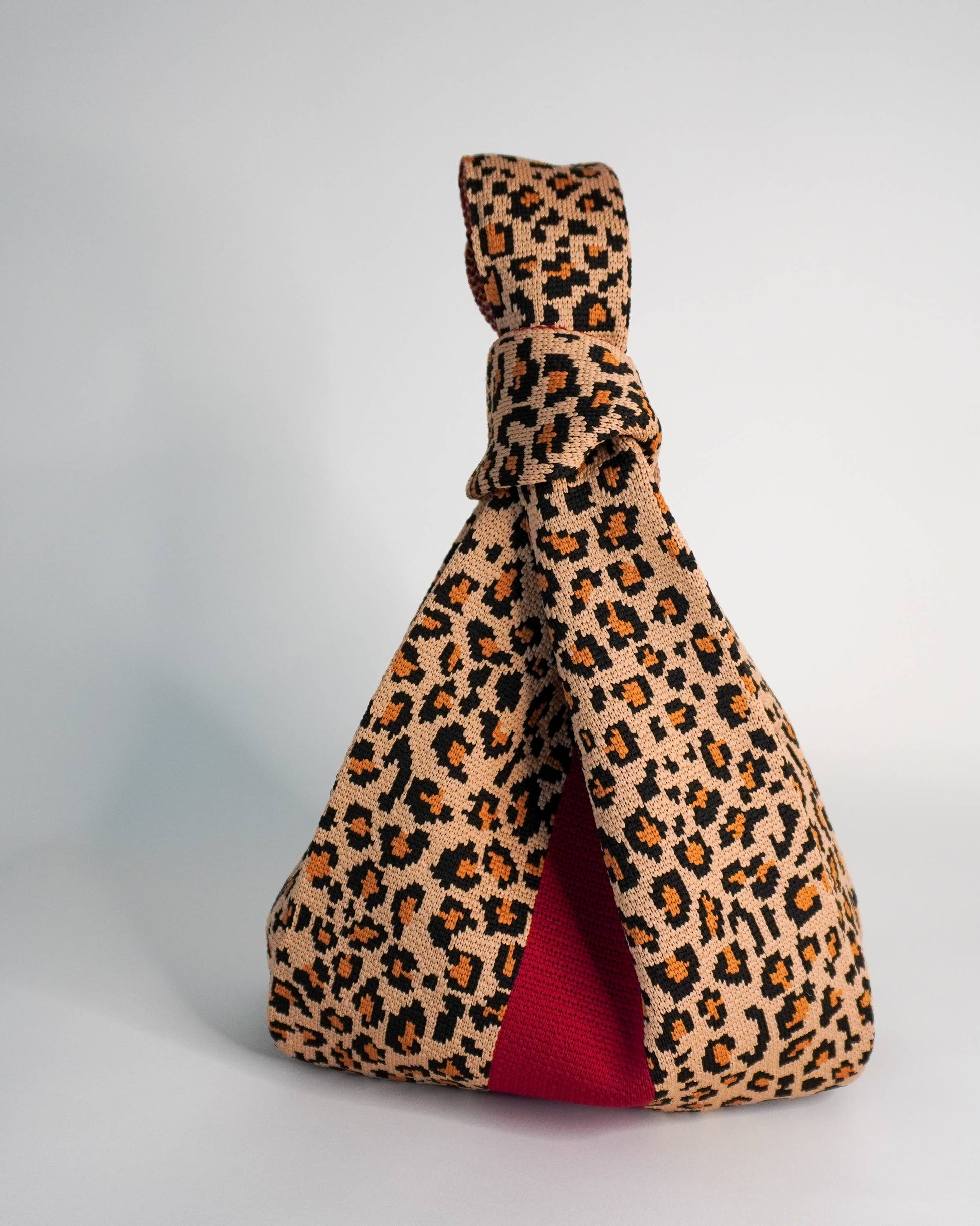 Leopard print bag with a red stripe on a white background