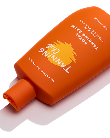 Orange bottle of Tanning Oil with a white label on a white background