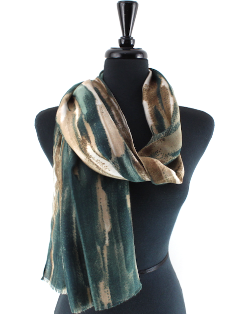 A lightweight scarf with an abstract brushstroke pattern in dark green, beige, and brown, draped on a black mannequin torso against a white background.