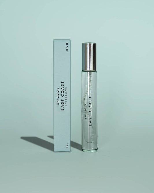 Perfume bottle and packaging with 'Botanica East Coast' branding on a light green background