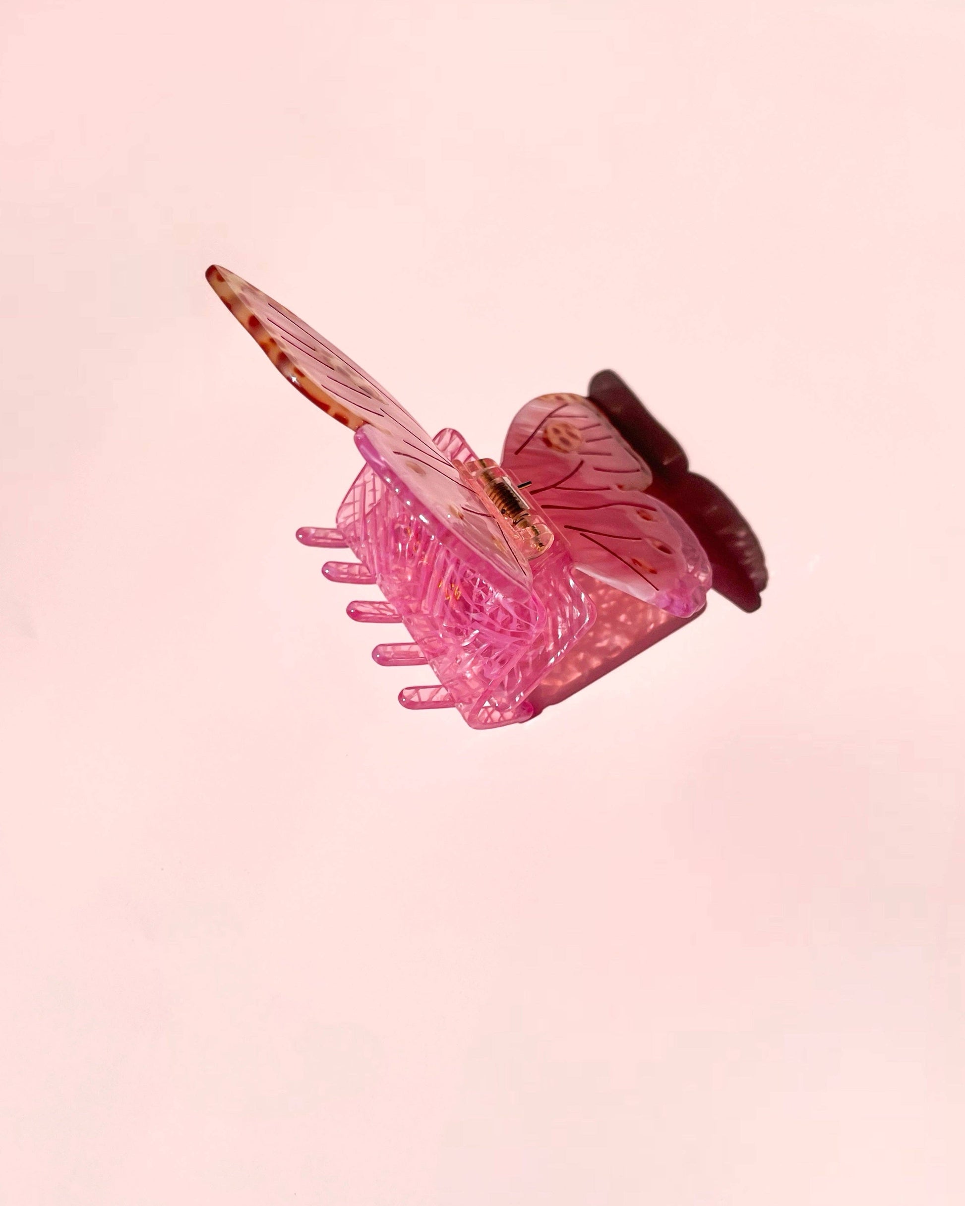 Pink butterfly hairclip on a pink background