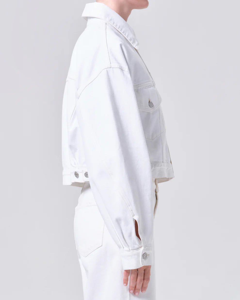 Person wearing a white outfit on a plain background
