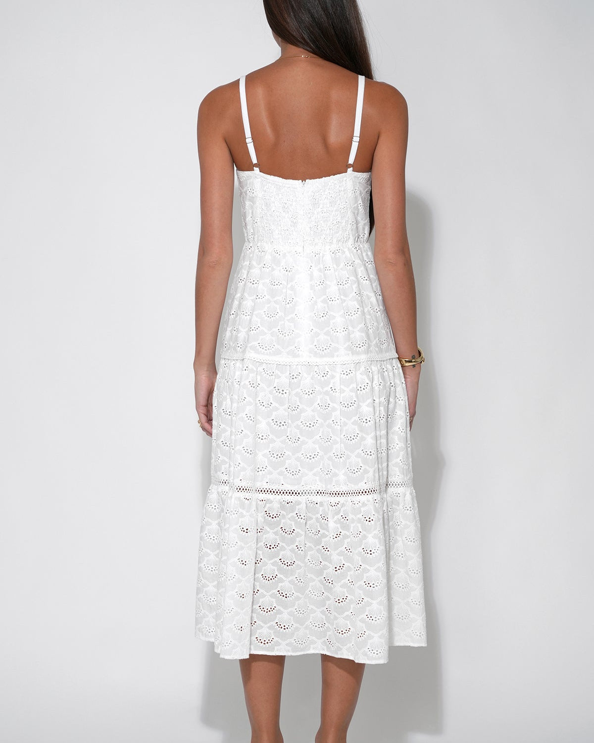 Back view of the Lina Tiered Strappy Cotton Eyelet Embroidered Midi Dress in front of a white background.