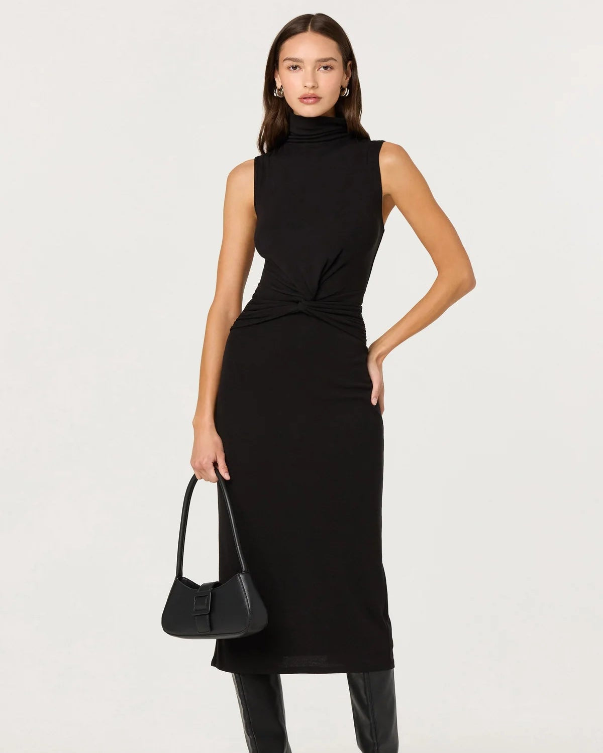 Woman wearing a black sleeveless dress with a plain background