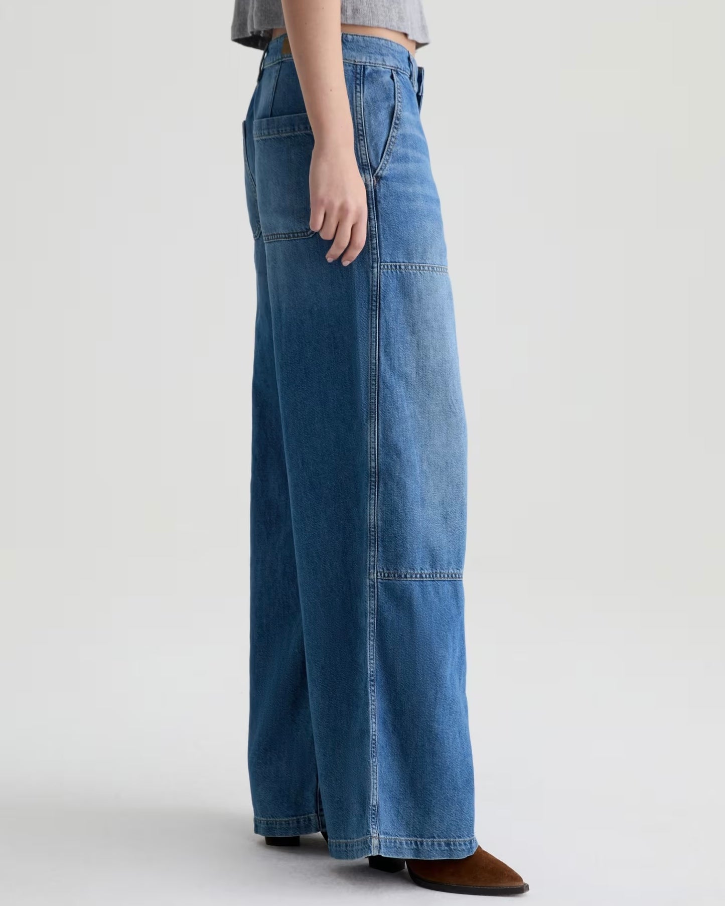 Person wearing blue wide-leg jeans on a white background