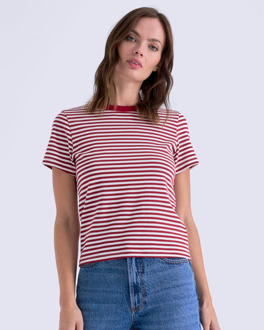 Woman wearing a red and white striped shirt and blue jeans on a white background
