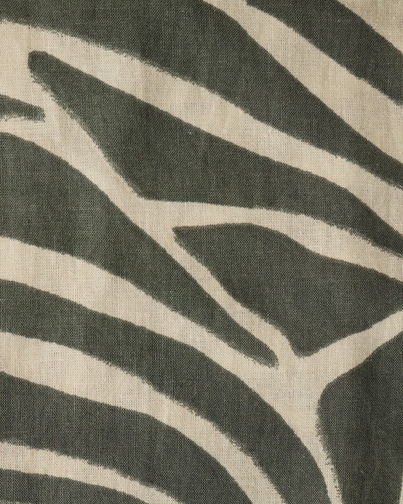 Close-up of a fabric with a zebra stripe pattern in green and beige.
