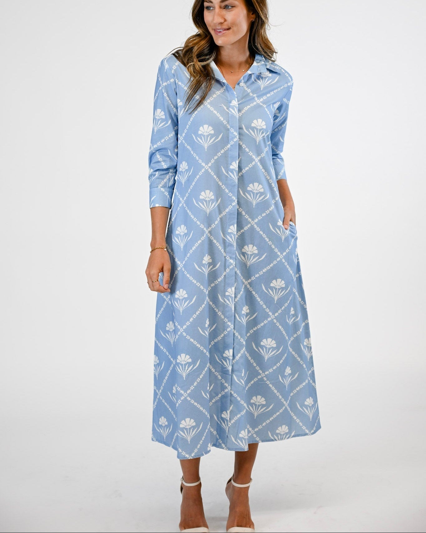 Woman wearing a blue patterned dress on a white background