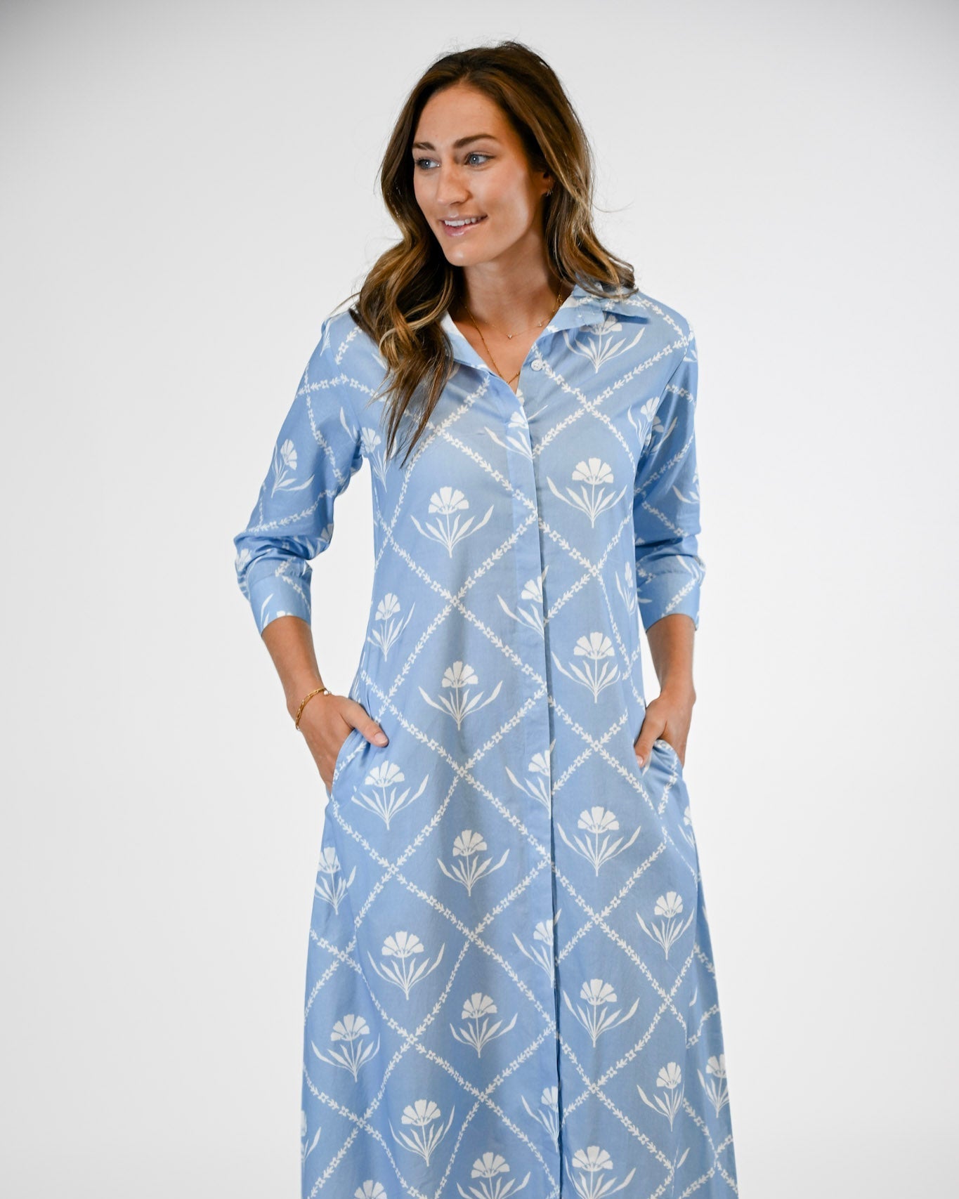 Woman wearing a blue floral dress against a white background