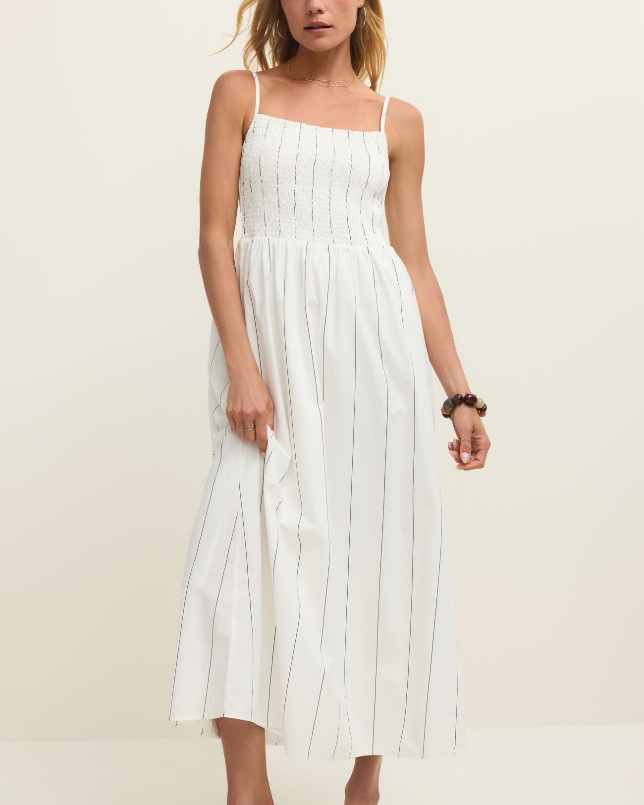 Woman wearing a white dress against a plain background