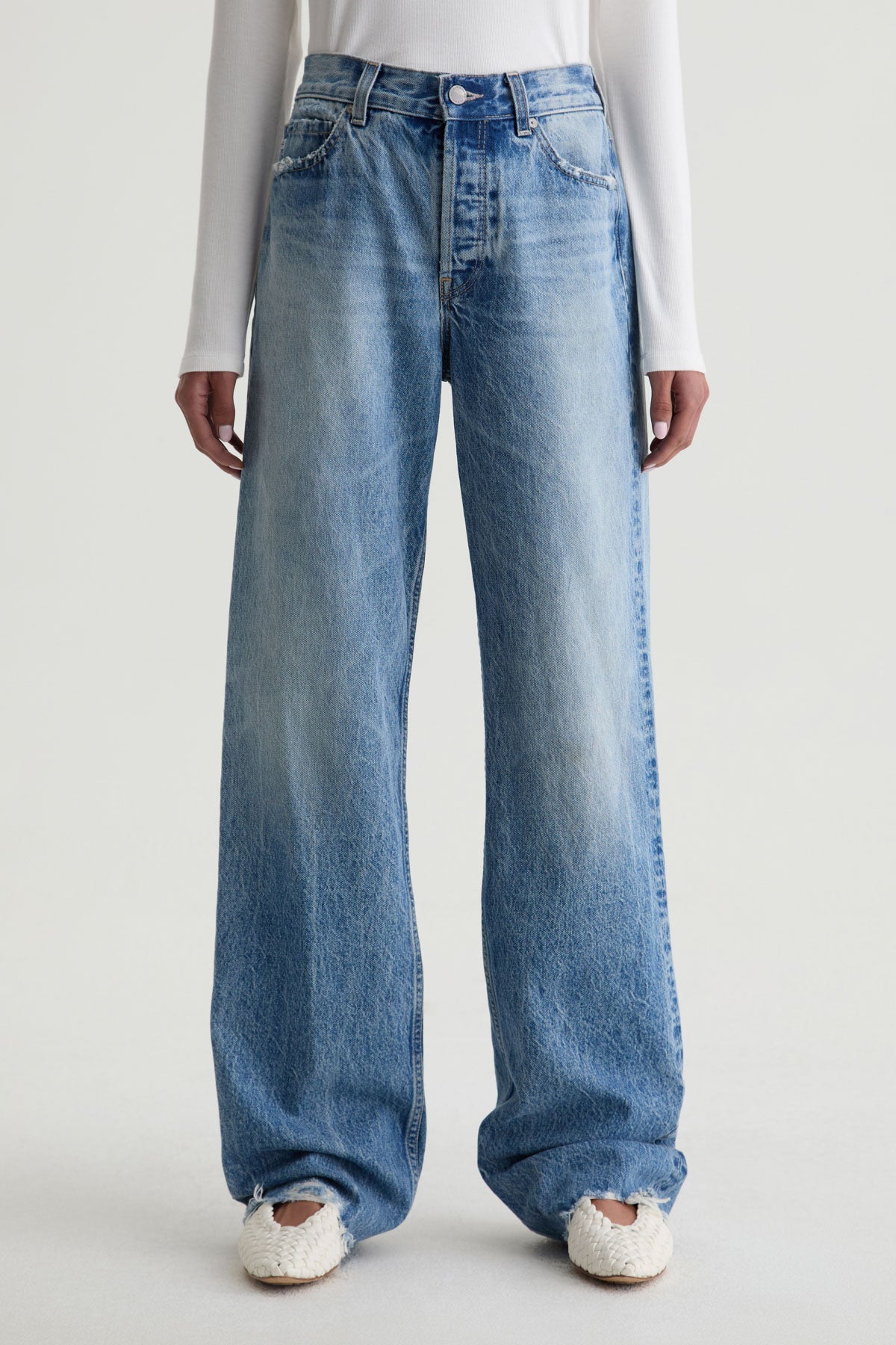 Blue jeans worn by a person on a white background