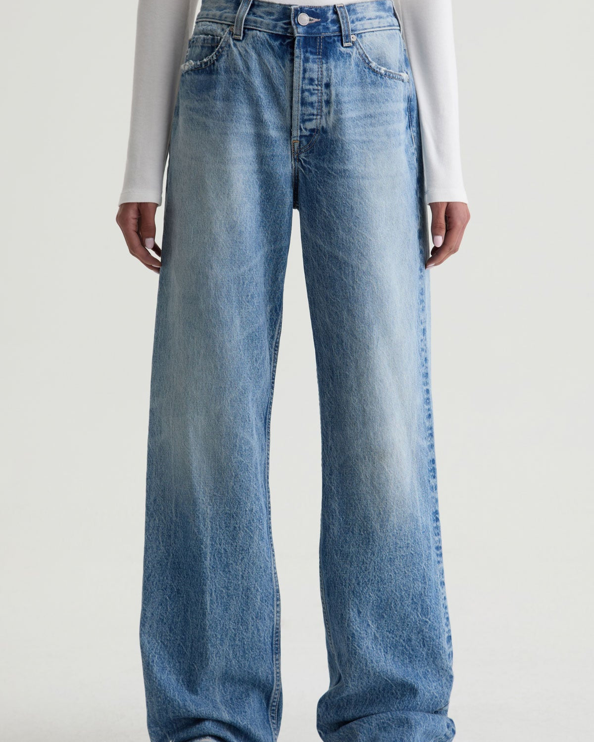 Blue jeans worn by a person on a white background