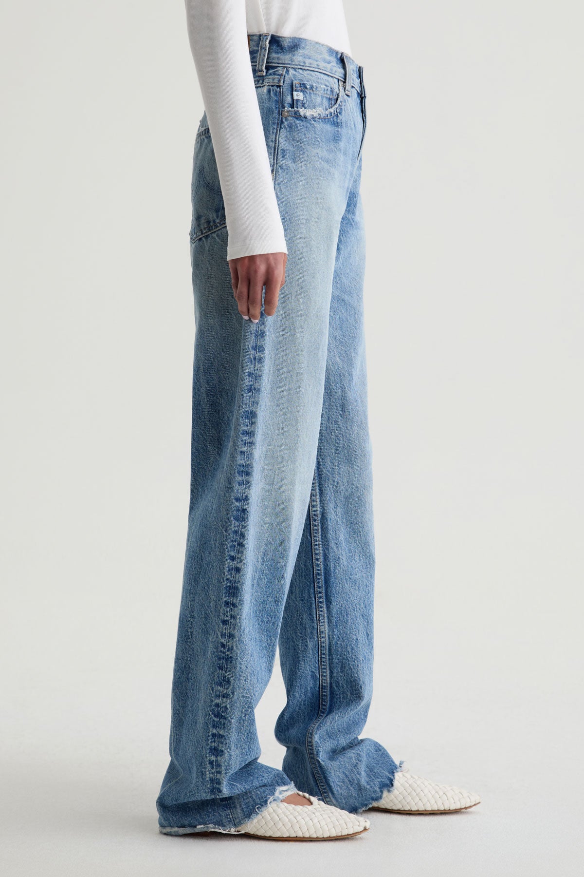 Blue jeans worn by a person on a white background