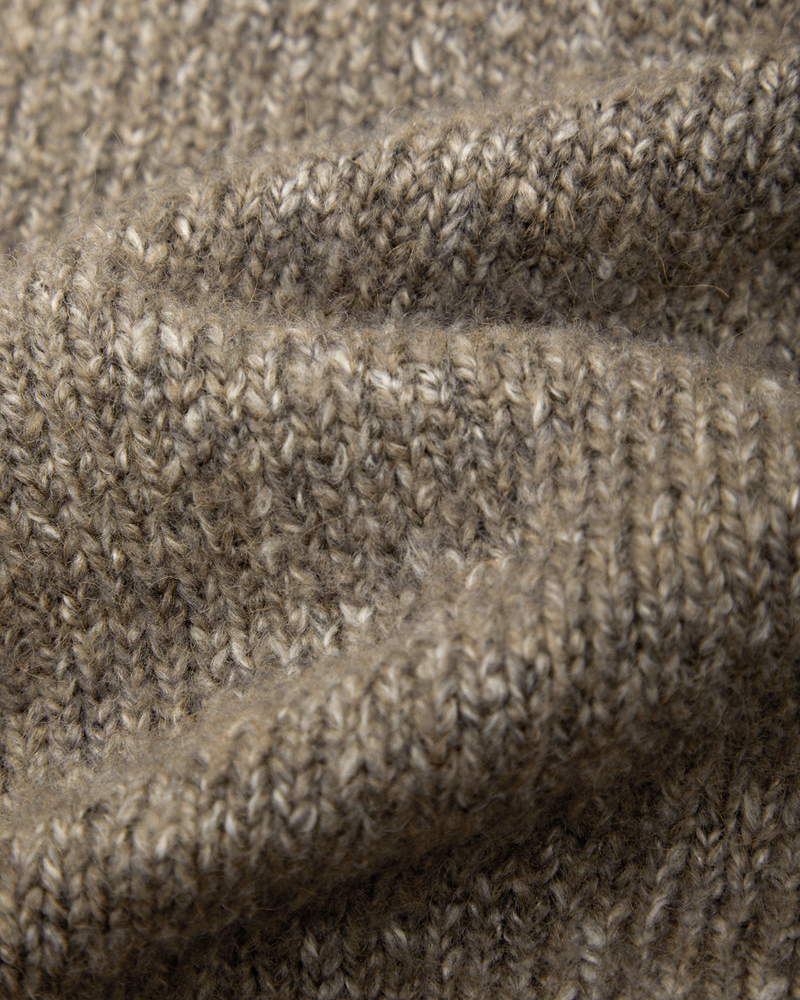 Close-up of a heathered knit fabric in a warm taupe-brown color, showing the detailed texture of the yarn and stitches.